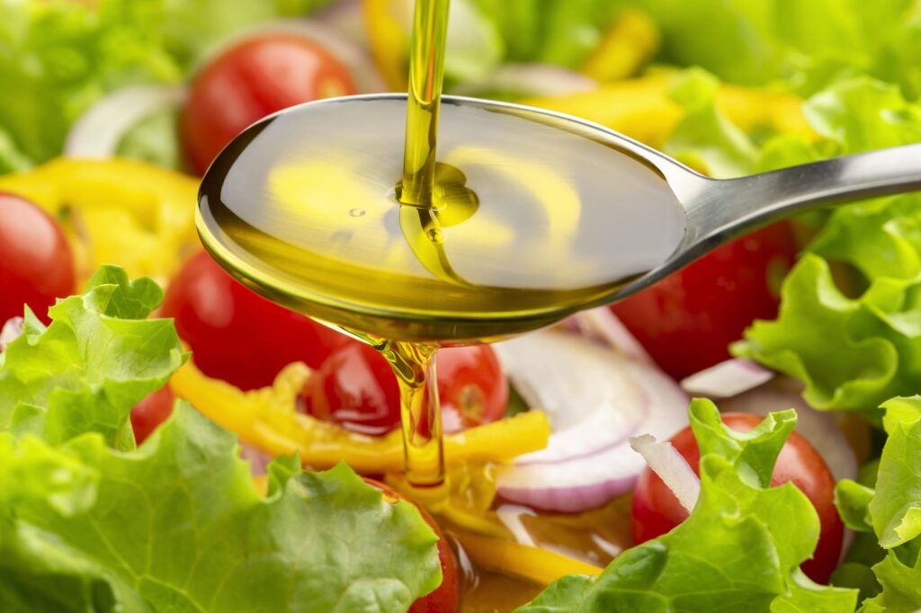 サラダにオリーブオイルをかける様子