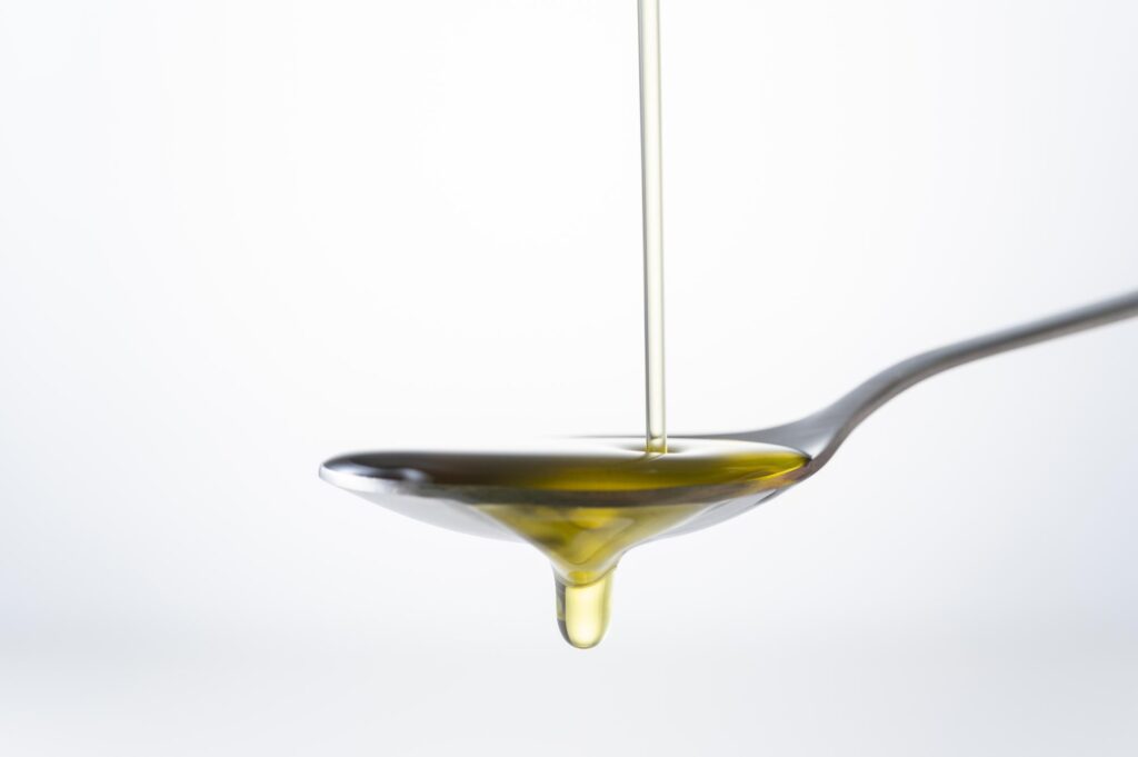 スプーンに垂れるオリーブオイル