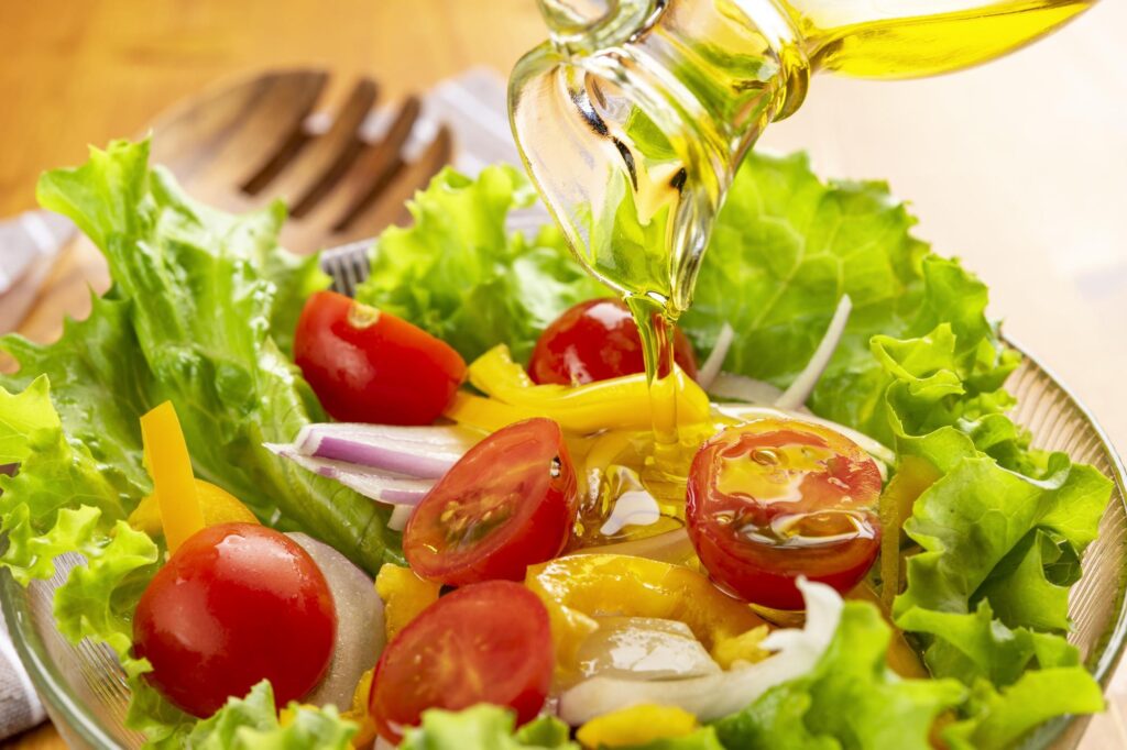 サラダにオリーブオイルをかける様子