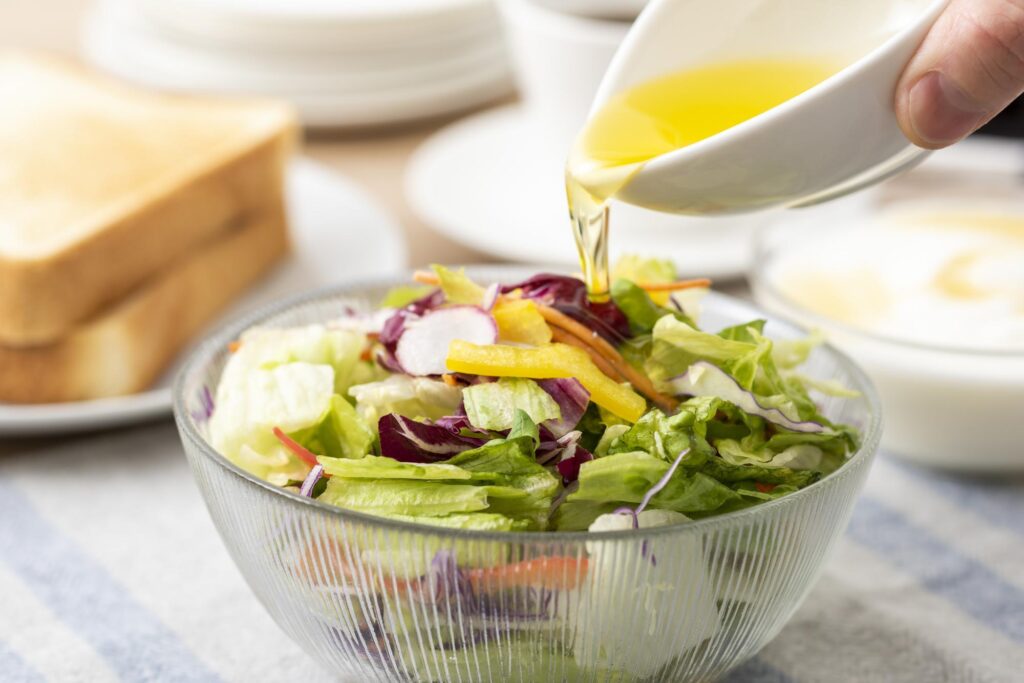 サラダにオリーブオイルをかける様子
