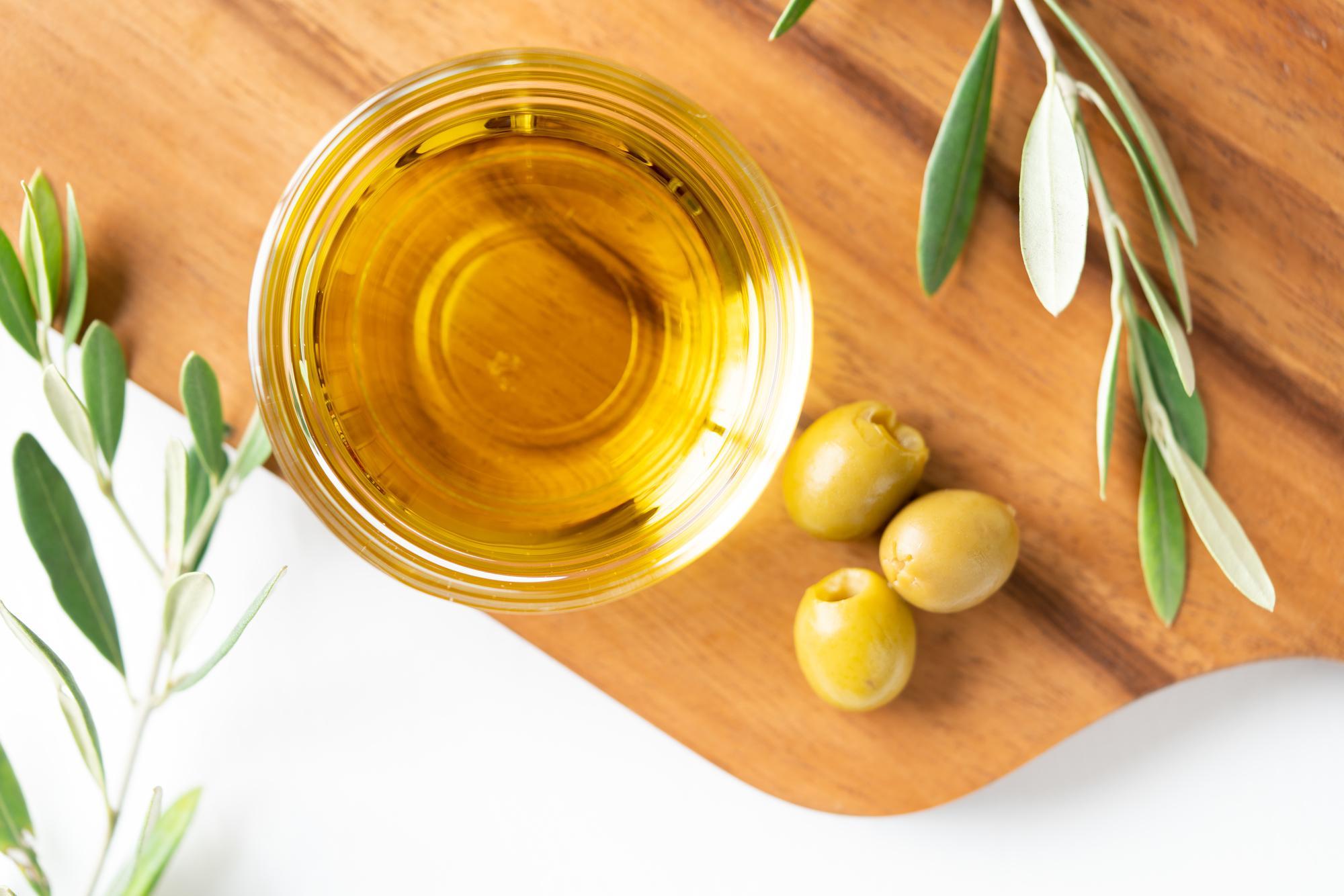 カッティングボードの上に置いたオリーブやオリーブオイル