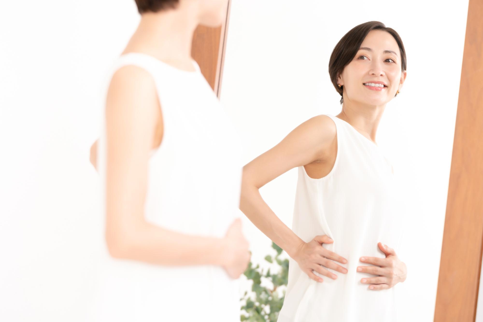 全身鏡で体形を確認する女性