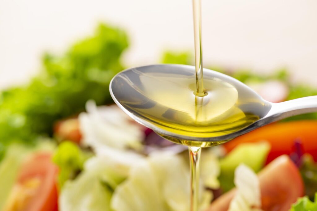 サラダにオリーブオイルを垂らす様子