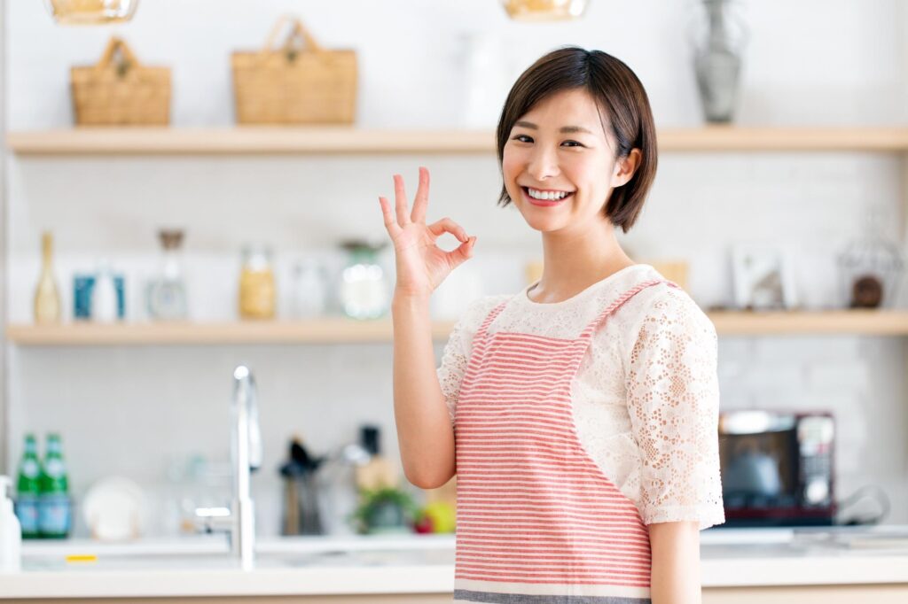 キッチンでOKサインをする女性