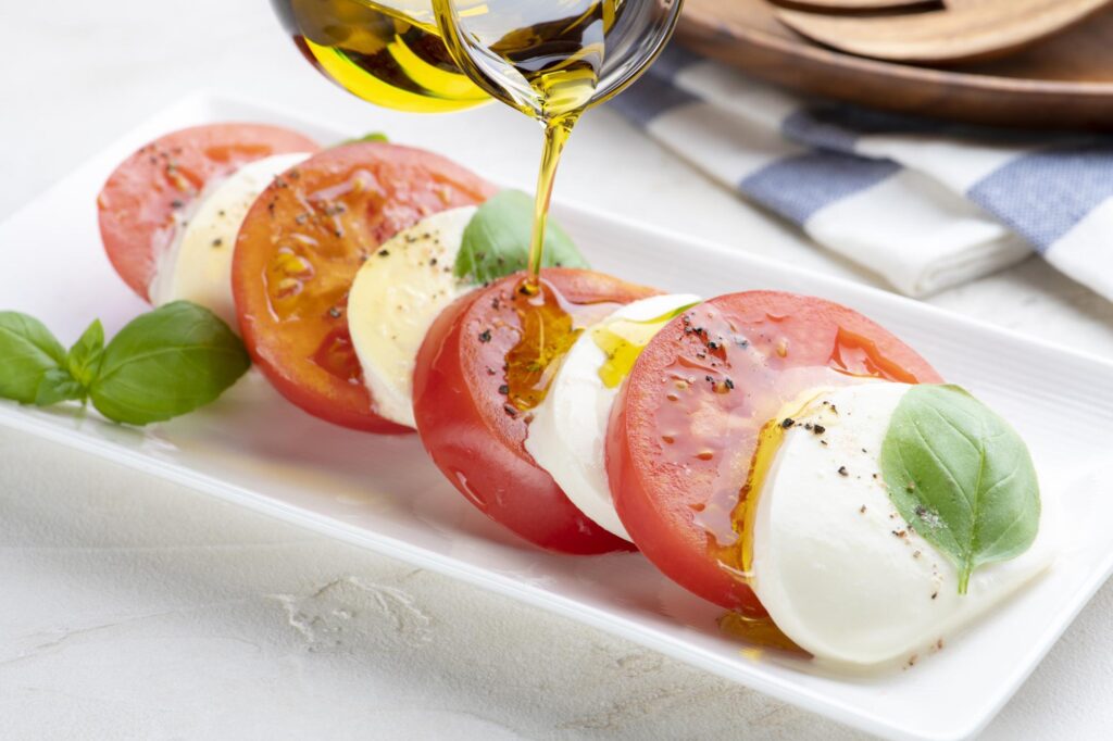 カプレーゼにオリーブオイルをかける様子